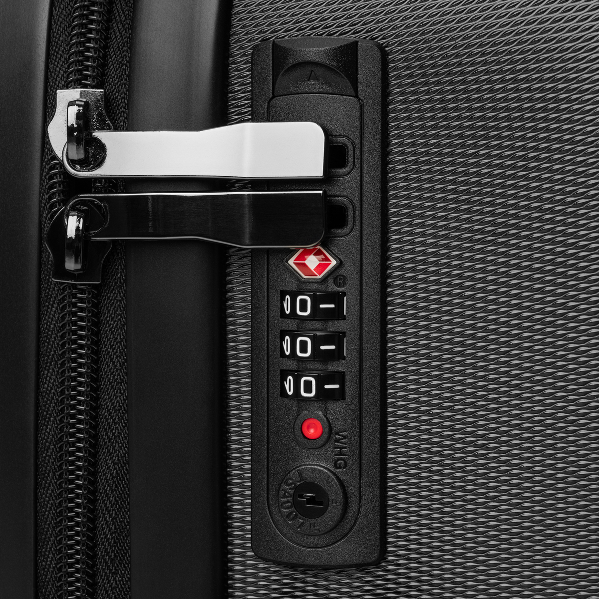 Close-up of a suitcase handle and lock mechanism on a textured surface