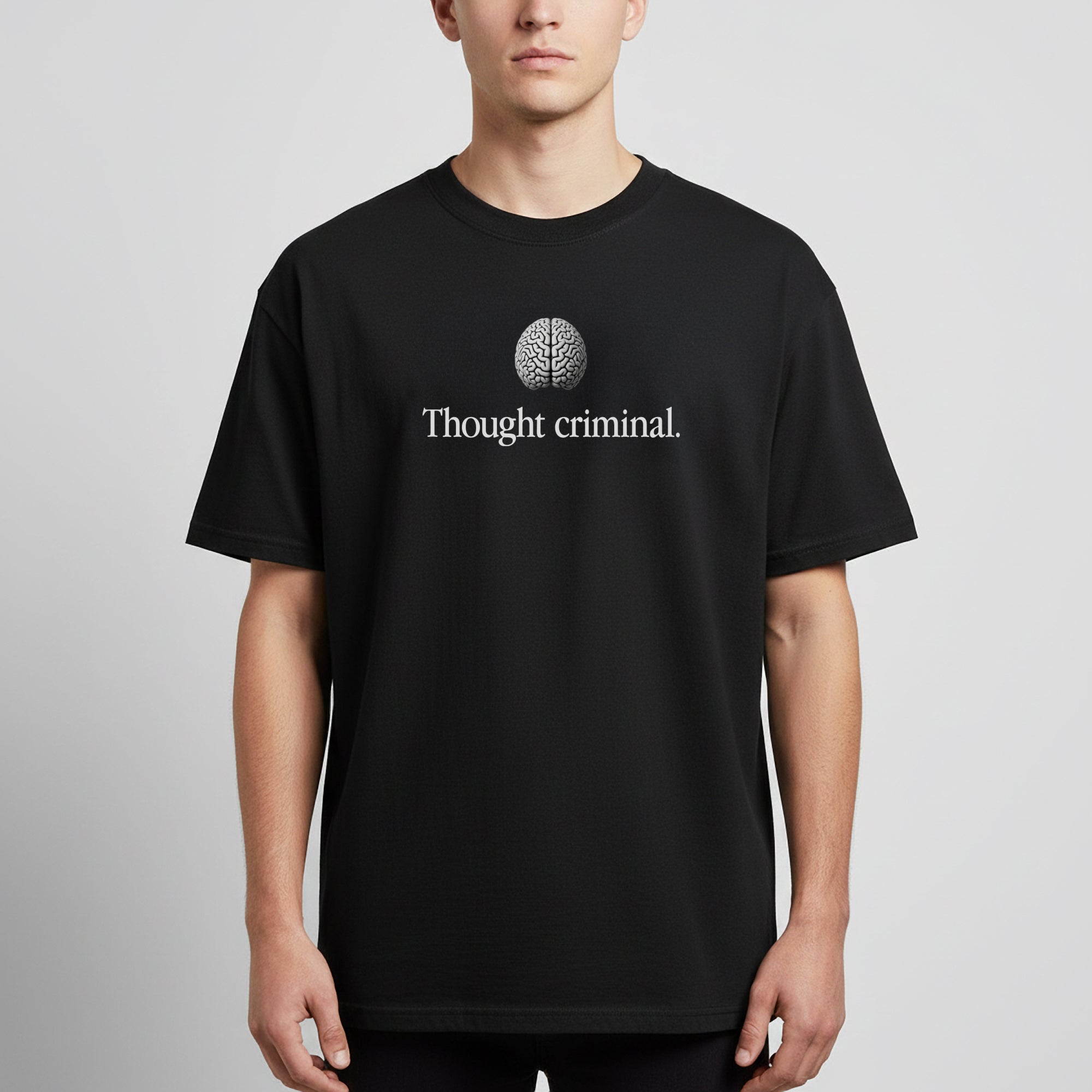 A man wearing a Thought Criminal parody shirt showing a words Thought Criminal with a brain above from Liberty Maniacs.