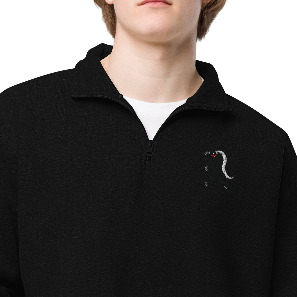 Model wearing the Black Heraldic Honey Badger fleece quarter-zip, close front view showing chest embroidery and open collar over a white shirt