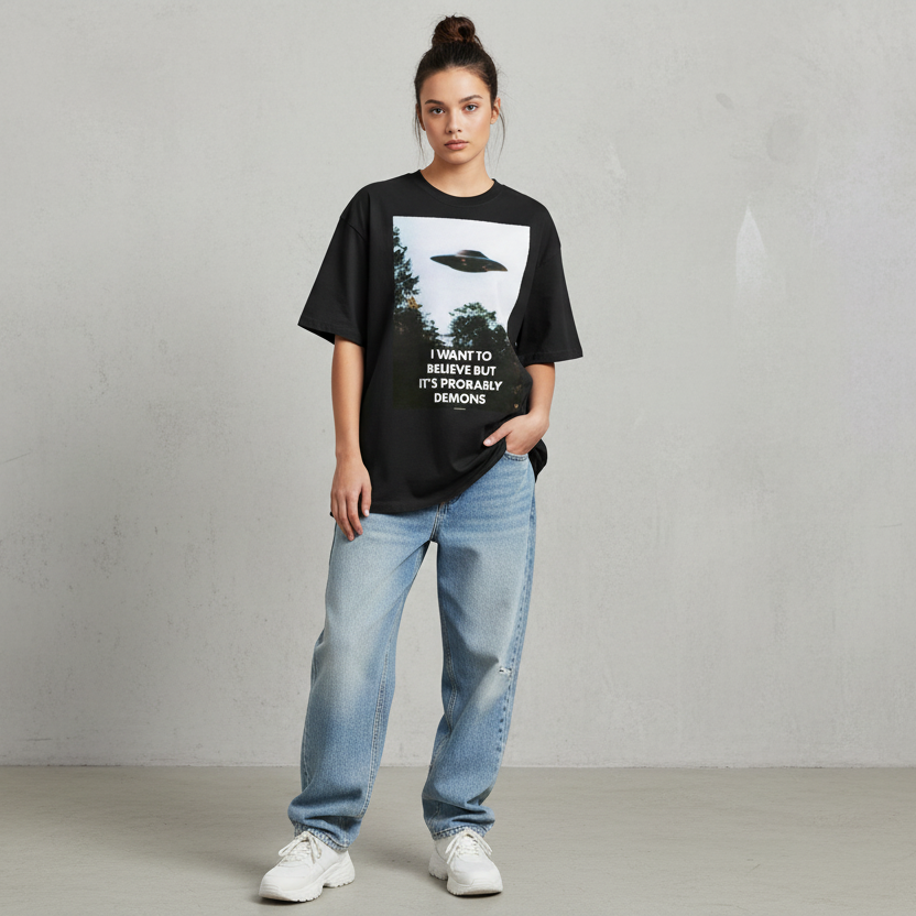 Person wearing a black t-shirt with a graphic design and text, standing against a plain background