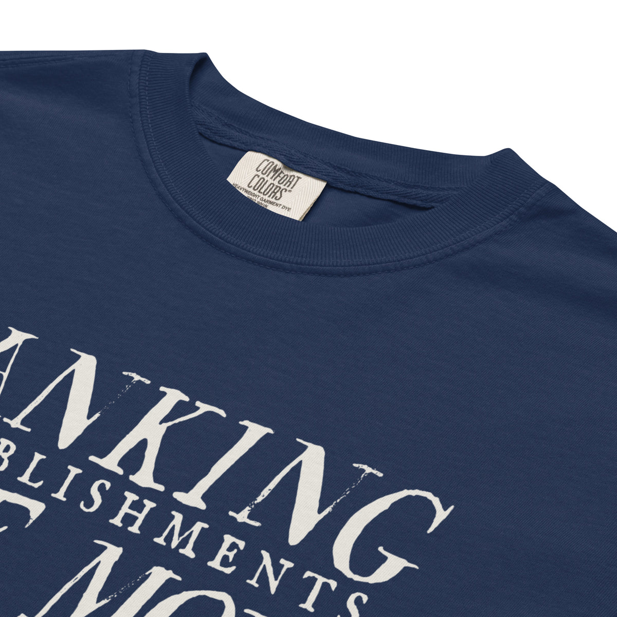 Close-up of True Navy Dangerous Banking T-shirt collar, Comfort Colors label and cream quote lettering