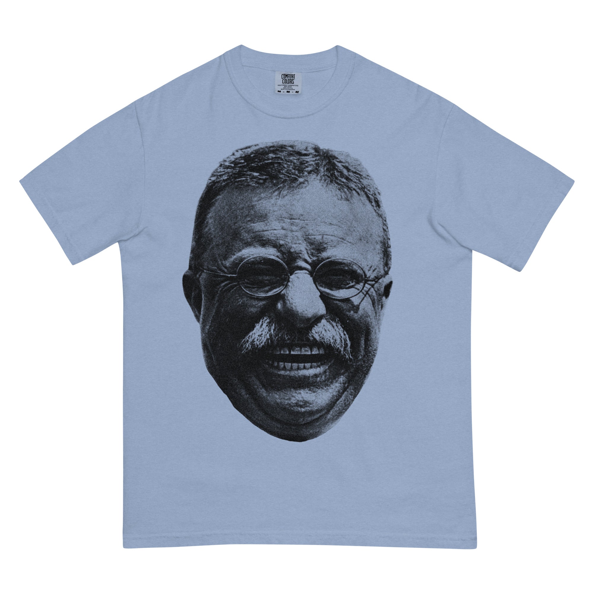 Man wearing a light blue Teddy Roosevelt Laugh Garment-dyed Heavyweight Tee on a gray background
