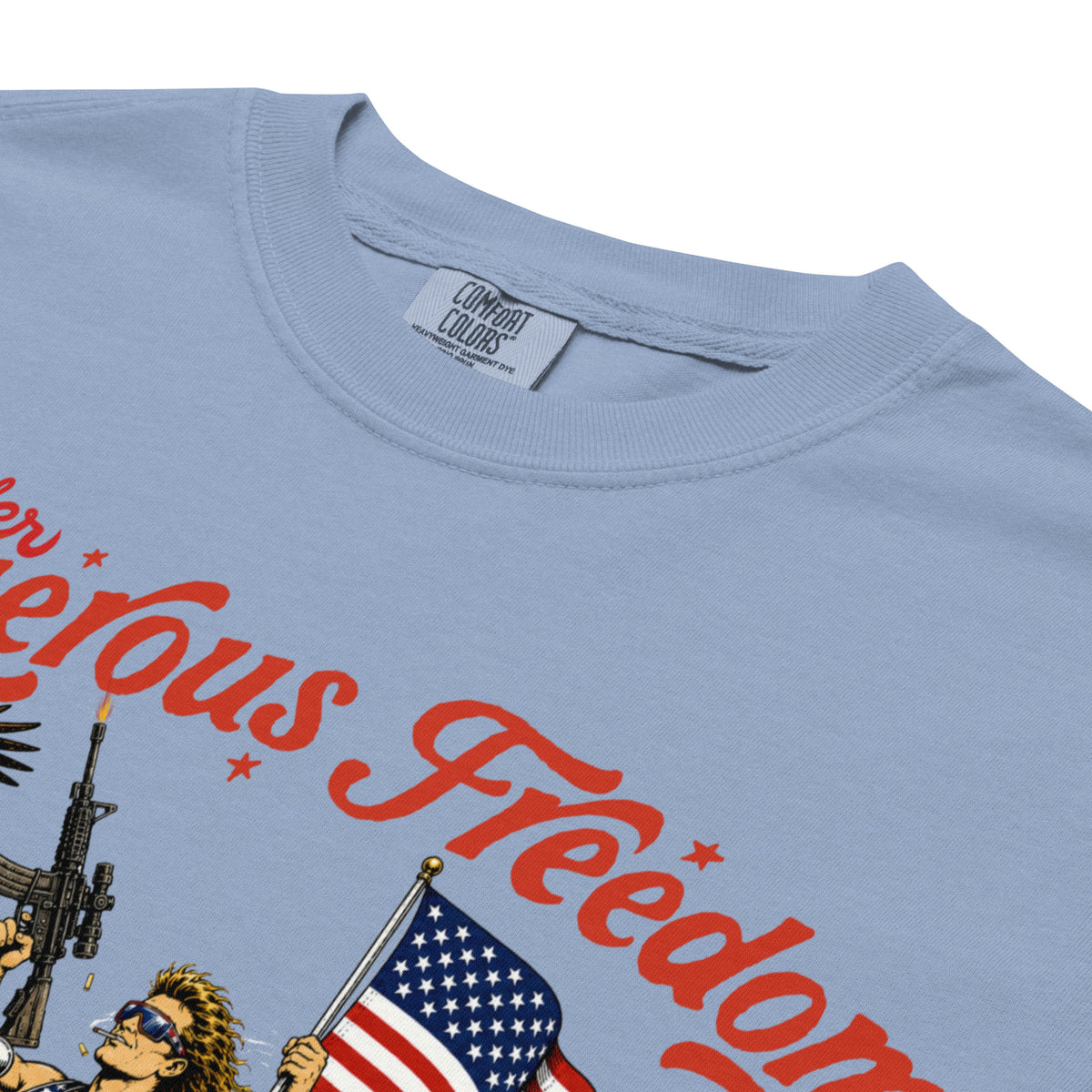 Close-up of a light blue t-shirt showing the inner neck label which reads 'COMBAT COLORS', along with a graphic print featuring red text and an illustration of a person holding an American flag.