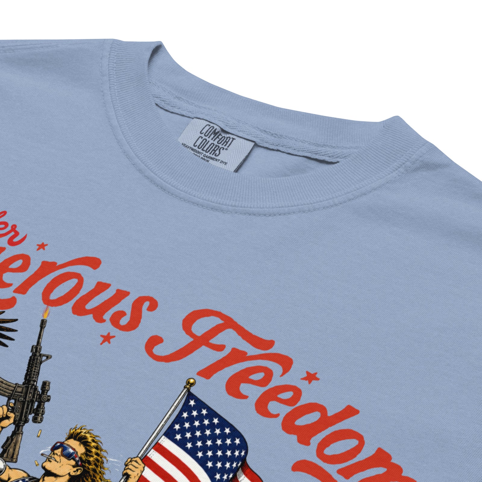 Close-up of a light blue t-shirt showing the inner neck label which reads 'COMBAT COLORS', along with a graphic print featuring red text and an illustration of a person holding an American flag.