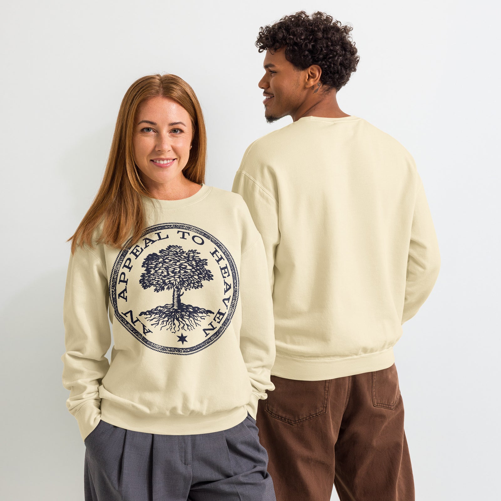 Two people wearing cream-colored An Appeal to Heaven Unisex Garment-dyed fleece Crewneck Sweatshirt with a tree design and text on a plain background