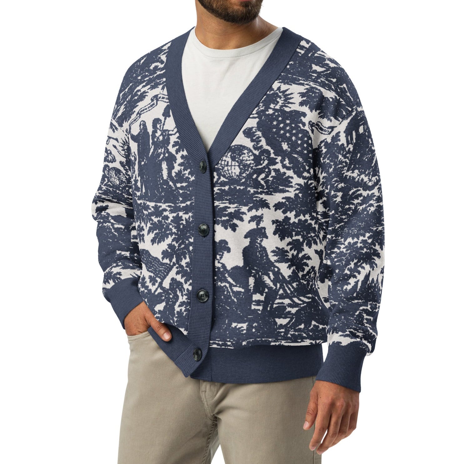 A man wearing a navy blue and white toile pattern cardigan over a white t-shirt and khaki pants, photographed against a solid white background.