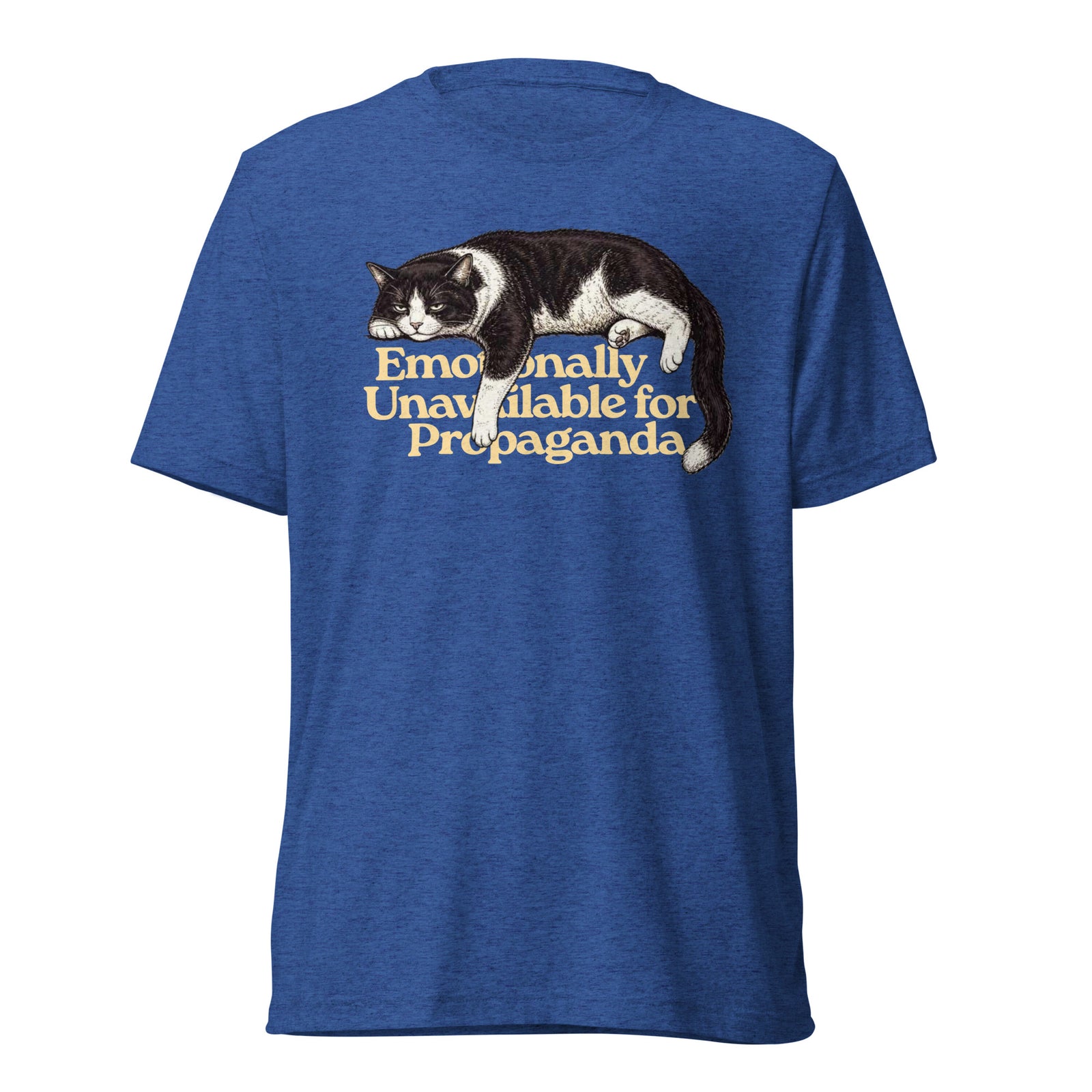 A heather blue short-sleeve t-shirt with a graphic of a black and white cat lying down above the text 'Emotionally Unavailable for Propaganda' in a warm yellow font, shown against a plain white background.