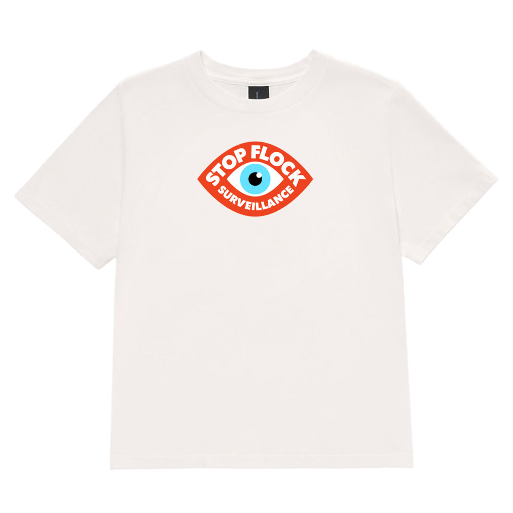 An off-white short-sleeve crewneck t-shirt featuring a red and blue graphic on the chest that reads 'STOP FLOCK SURVEILLANCE' in an eye-shaped design.