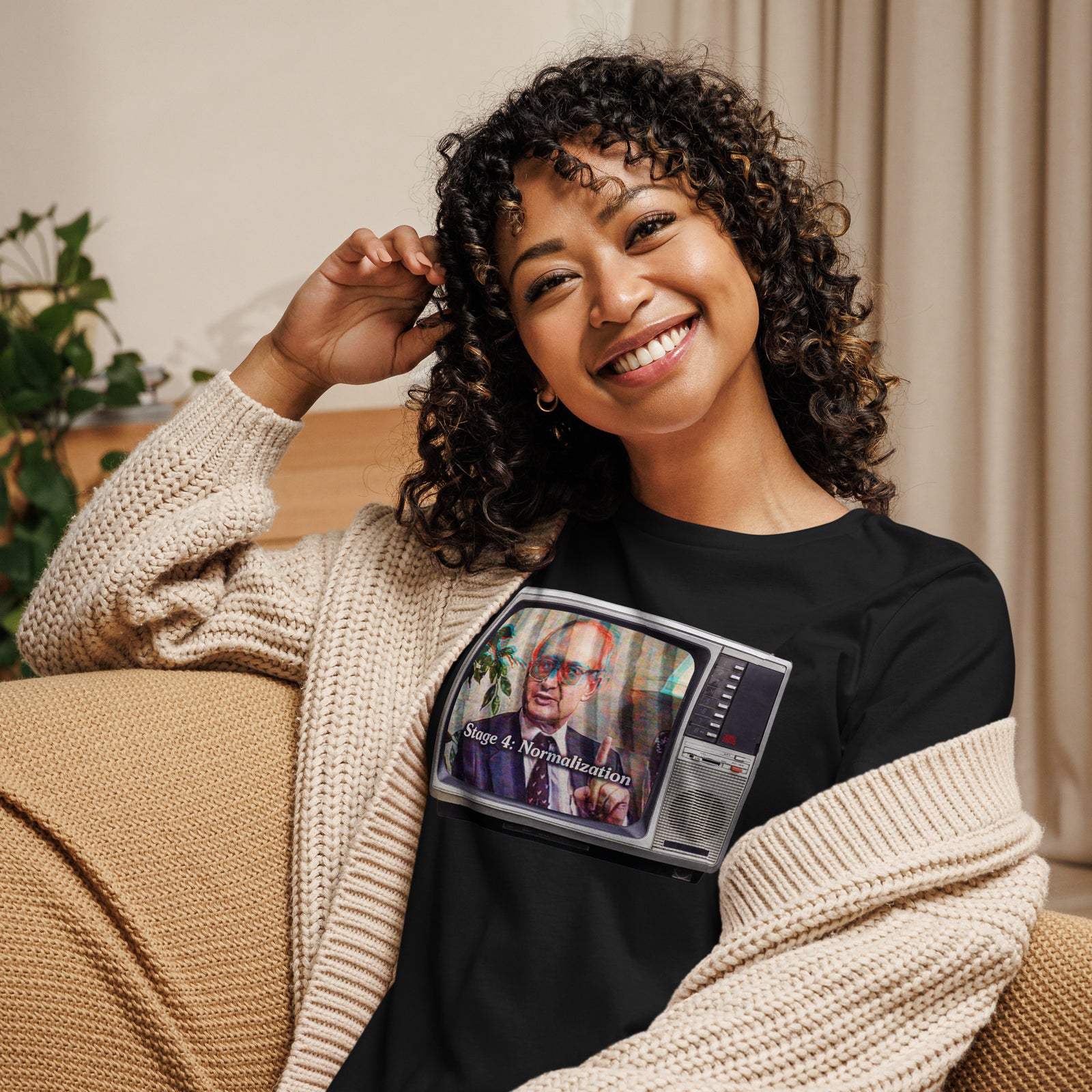 Woman wearing a black Yuri Bezmenov retro TV graphic tee under a beige cardigan