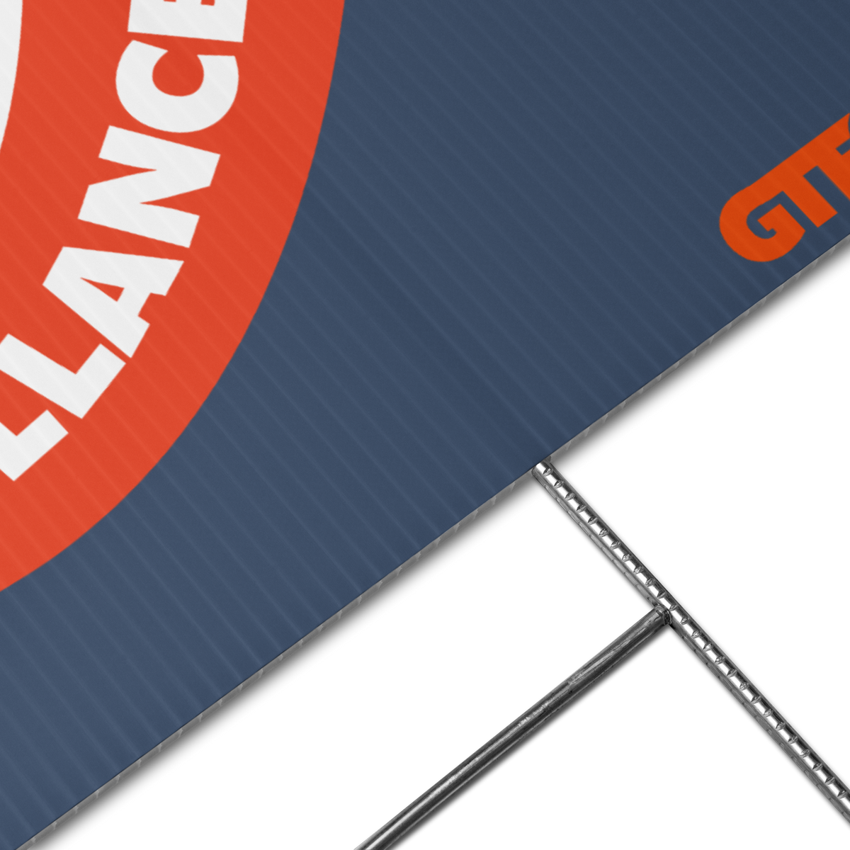 Close-up of a blue corrugated display banner with a red circular graphic, white partial text, and part of an orange logo, supported by metal stand legs on a white background.