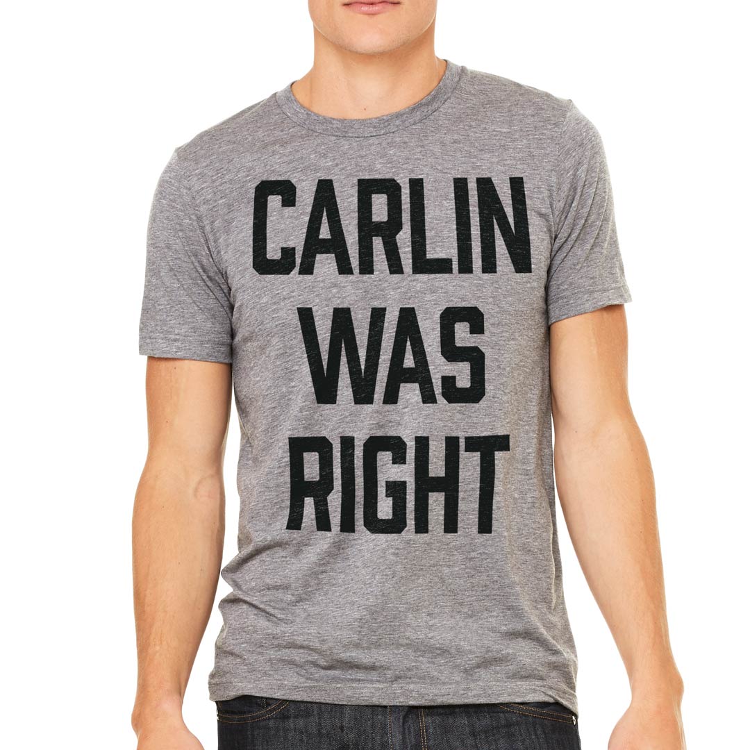 A person wearing a gray crew neck t-shirt with the text &#39;CARLIN WAS RIGHT&#39; printed in black block letters.