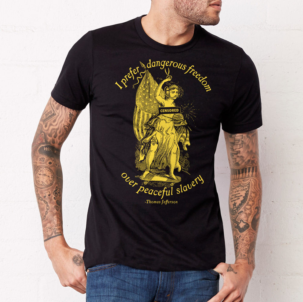A black t-shirt with a graphic print of a person and the text 'I prefer dangerous freedom over peaceful slavery - Thomas Jefferson' by Liberty Maniacs