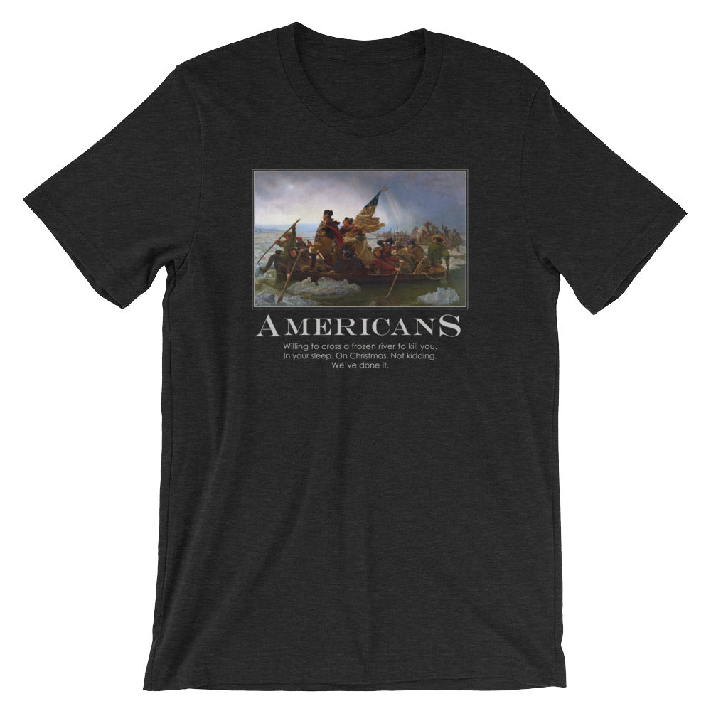 a heather black t-shirt from Liberty Maniacs. The t-shirt features a large graphic of the historical painting "Washington Crossing the Delaware." Below the painting, the word "AMERICANS" is written in a large, bold font. Underneath, smaller text reads: "Willing to cross a frozen river to kill you in your sleep. On Christmas. Not kidding. We've done it."