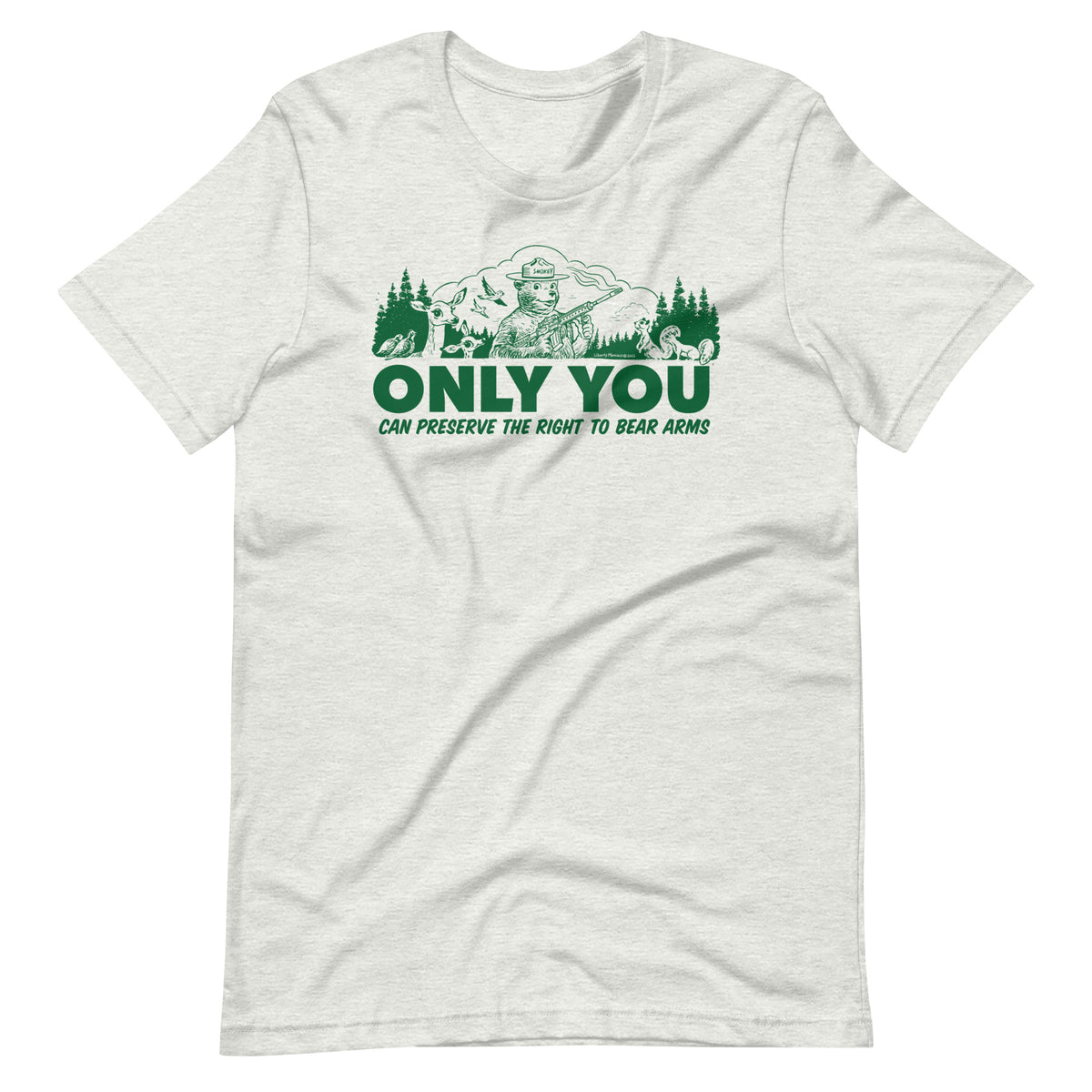 
A heather gray t-shirt with a green graphic. The graphic shows a cartoon bear resembling Smokey Bear, wearing a ranger hat and holding a hunting rifle. The bear is centered in a forest setting with a deer, squirrels, and birds nearby. Below the image, large text reads, &quot;ONLY YOU CAN PRESERVE THE RIGHT TO BEAR ARMS.&quot;