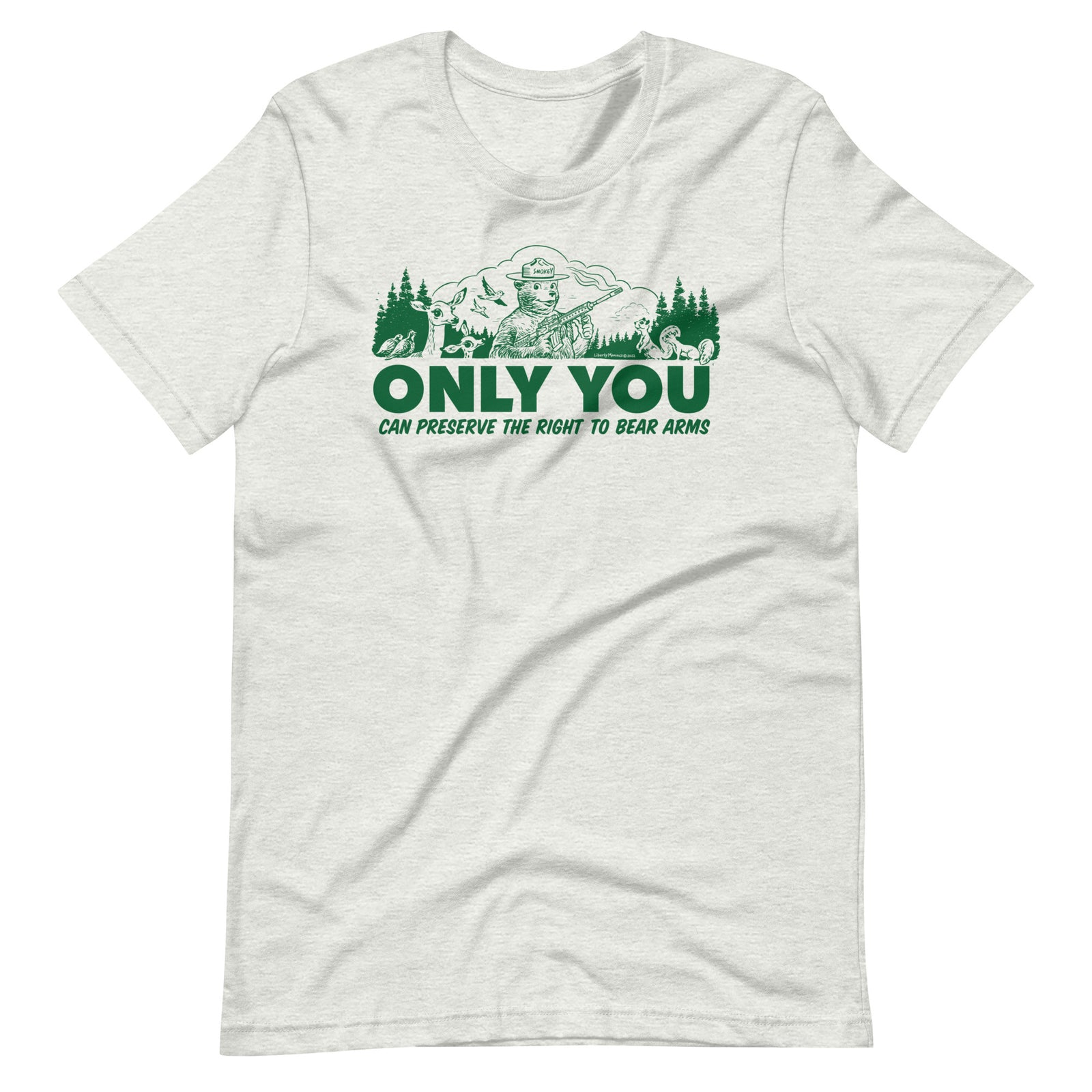 
A heather gray t-shirt with a green graphic. The graphic shows a cartoon bear resembling Smokey Bear, wearing a ranger hat and holding a hunting rifle. The bear is centered in a forest setting with a deer, squirrels, and birds nearby. Below the image, large text reads, "ONLY YOU CAN PRESERVE THE RIGHT TO BEAR ARMS."
